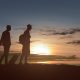 silhouette of two man with backpack and suitcase standing in the morning