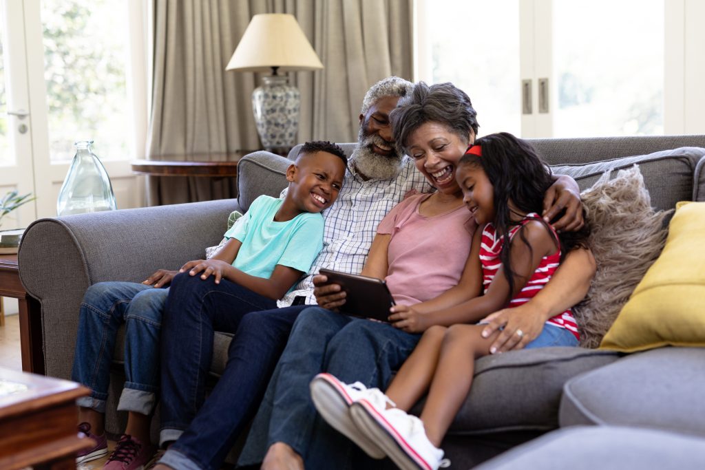 senior mixed race couple with their grandchildren at home