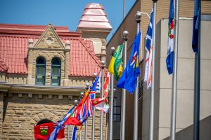 several provincial flags waving in the wind inn calgary, alberta.