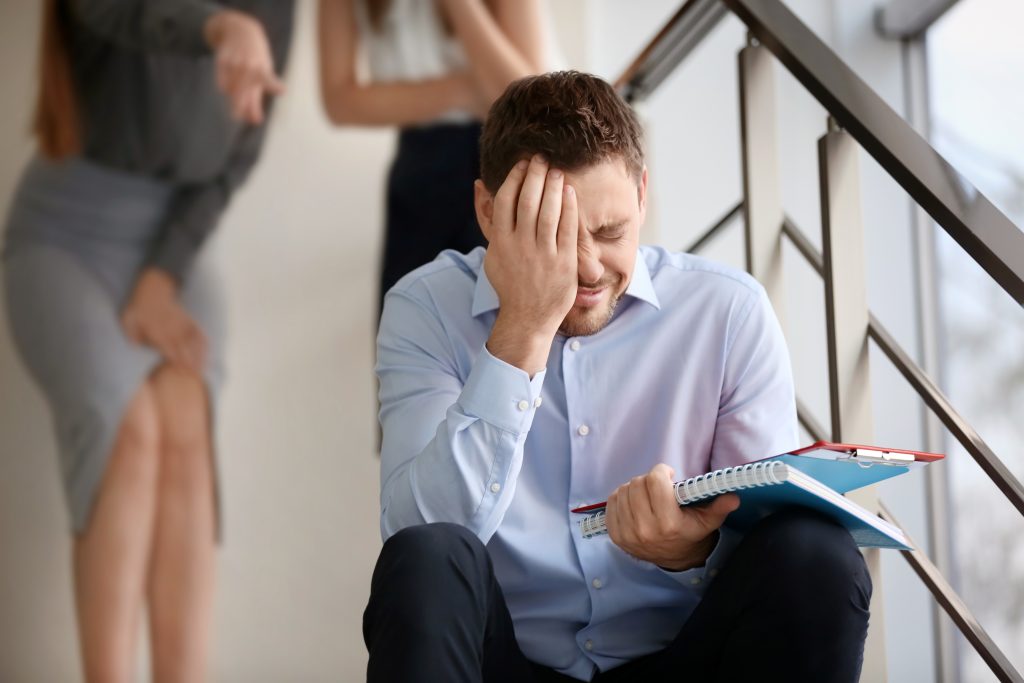 coworkers bullying their colleague on stairs at work